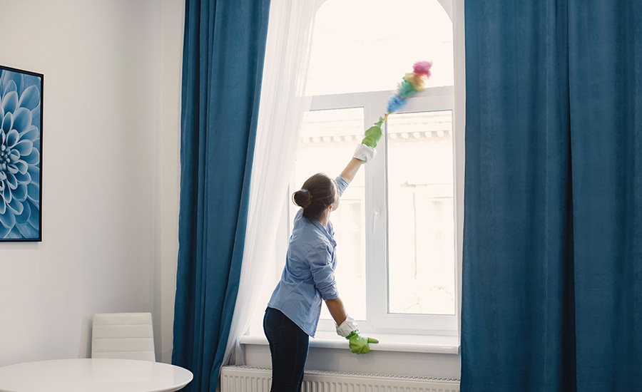 Femme qui enléve la poussière autours des vitres